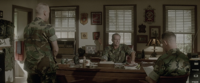 Wide shot frame from A Few Good Men — sitting, desk, book