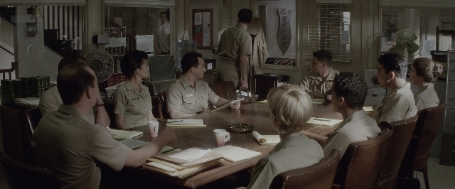 Wide shot frame from A Few Good Men — sitting, book, standing