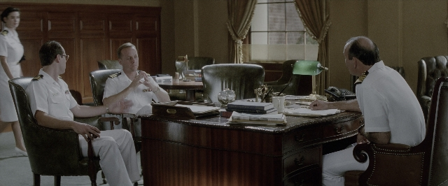 Wide shot frame from A Few Good Men — sitting, desk, book