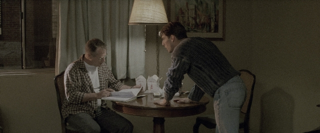 Wide shot frame from A Few Good Men — sitting, book, room