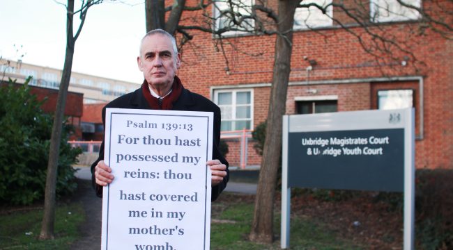 Проповедник, оштрафованный за демонстрацию библейского стиха, оспаривает зоны безопасности вокруг абортных клиник