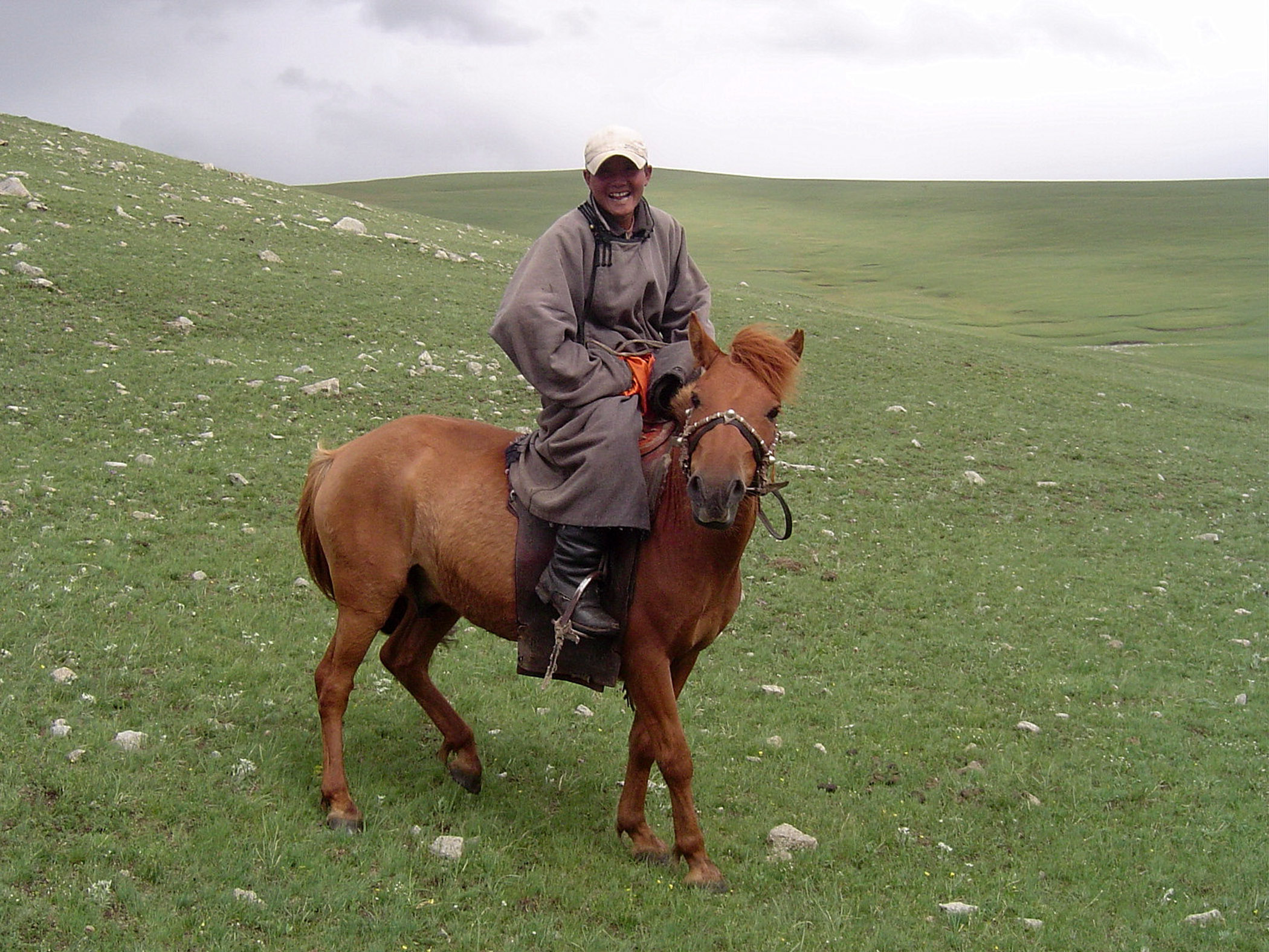 Путешественник поправляет одежду в ветреной степи