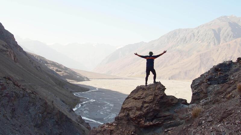 Путешественник, стоящий на смотровой площадке в горах