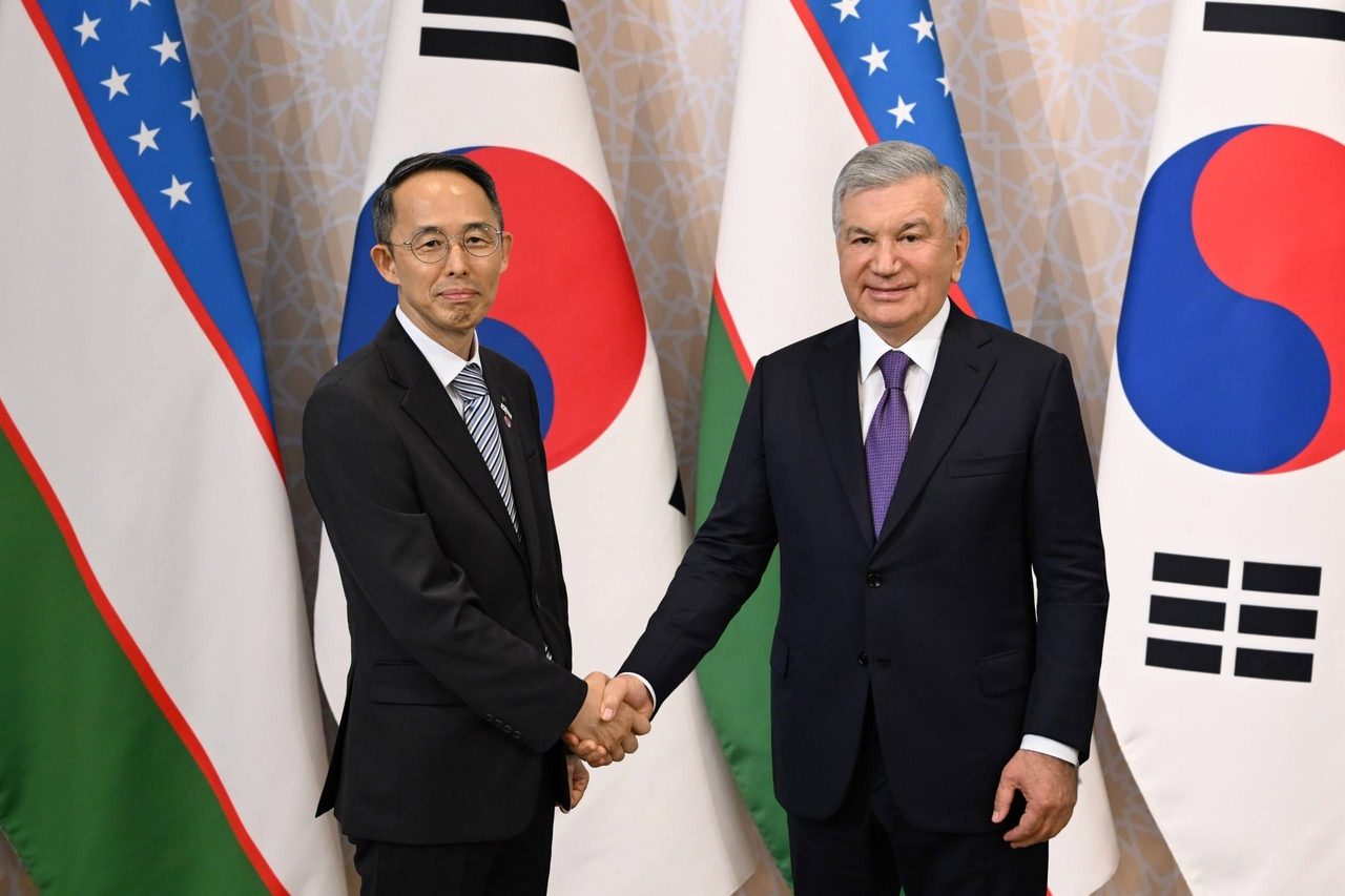 Korea Eximbank Chairman Hwang Ki-yeon (left) shakes hands with Uzbek President Shavkat Mirziyoyev at The Shilla Seoul on Tuesday to discuss ways to deepen economic cooperation betw