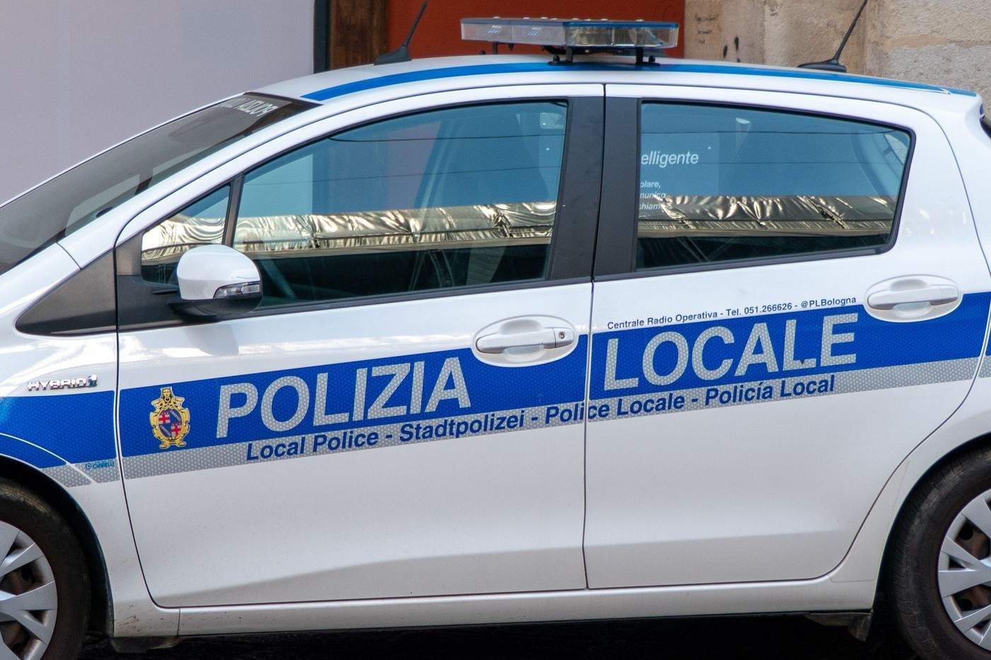 Bologna, Italia, 4 august 2026. Cadru de aproape, din profil, cu o mașină alb-albastră a poliției locale italiene (Polizia Locale).