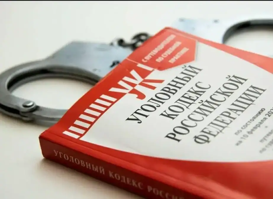 Наручники лежат рядом с книгой «Уголовный кодекс Российской Федерации».
