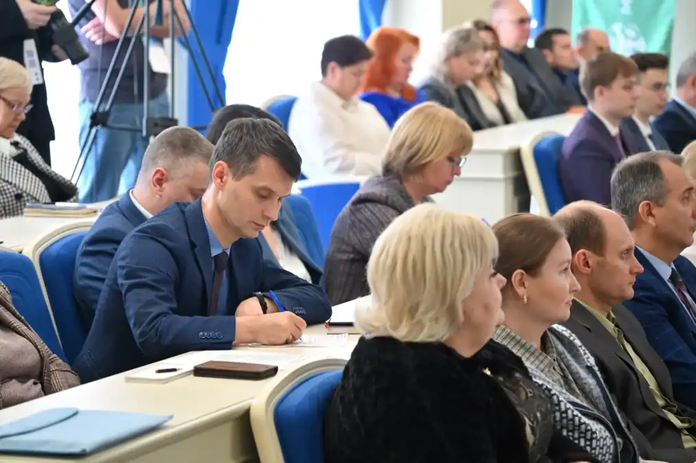 Участники деловой программы слушают выступление и делают записи в блокнотах.