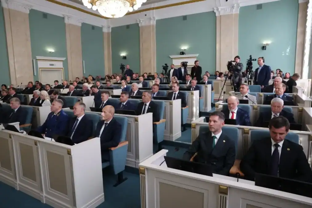 Депутаты сидят в зале заседаний Государственного Собрания.