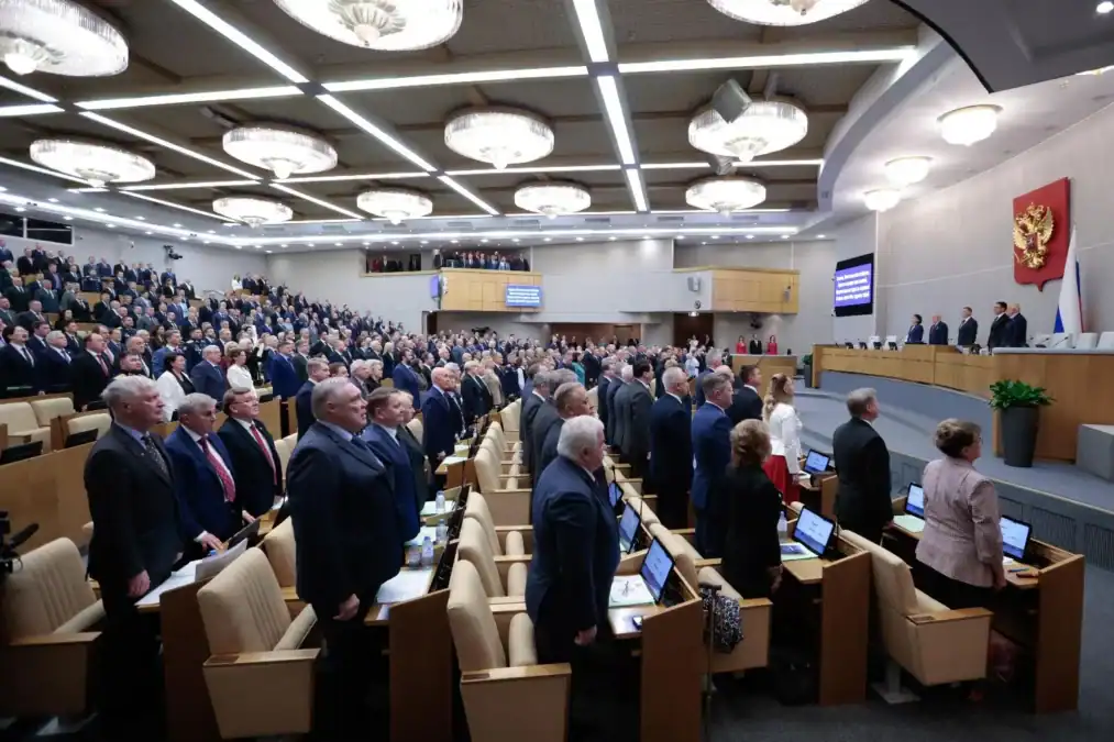 Участники заседания стоят в большом зале Государственной думы.