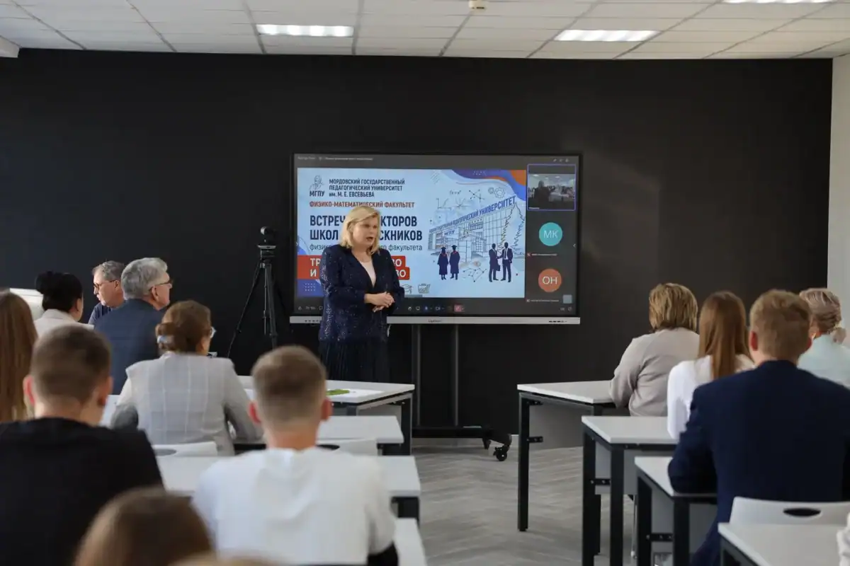 Выступающая проводит встречу перед студентами в университетской аудитории.