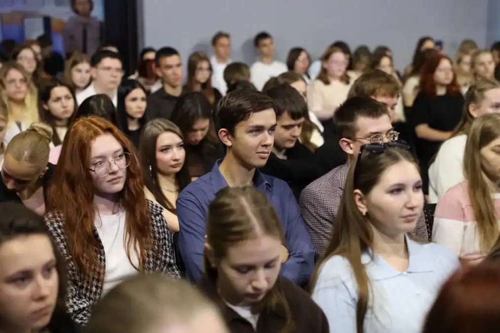 Студенты внимательно слушают выступающего в переполненном зале.