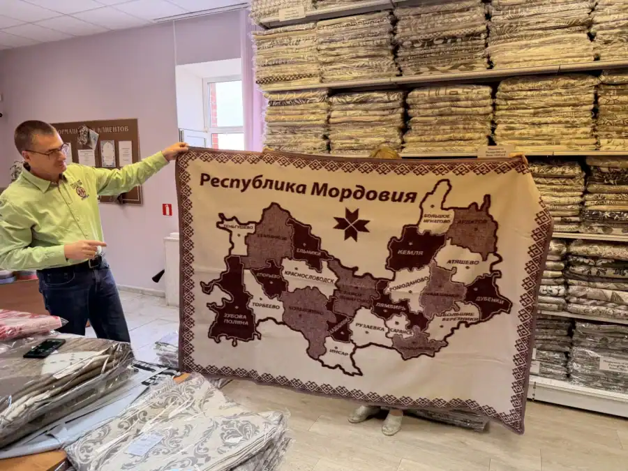 Мужчина показывает плед с картой и надписью «Республика Мордовия».
