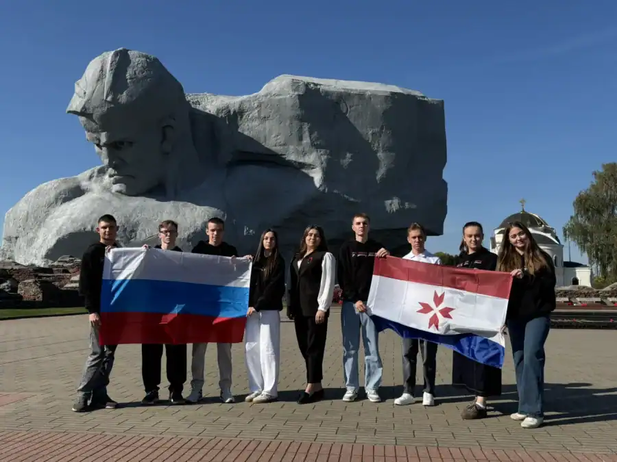 Участники делегации с флагами России и Мордовии у мемориала.