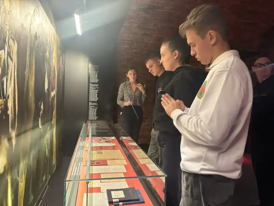 Молодые люди рассматривают экспозицию в музейном зале.