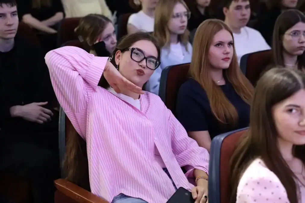 Студенты сидят в зрительном зале во время концерта.