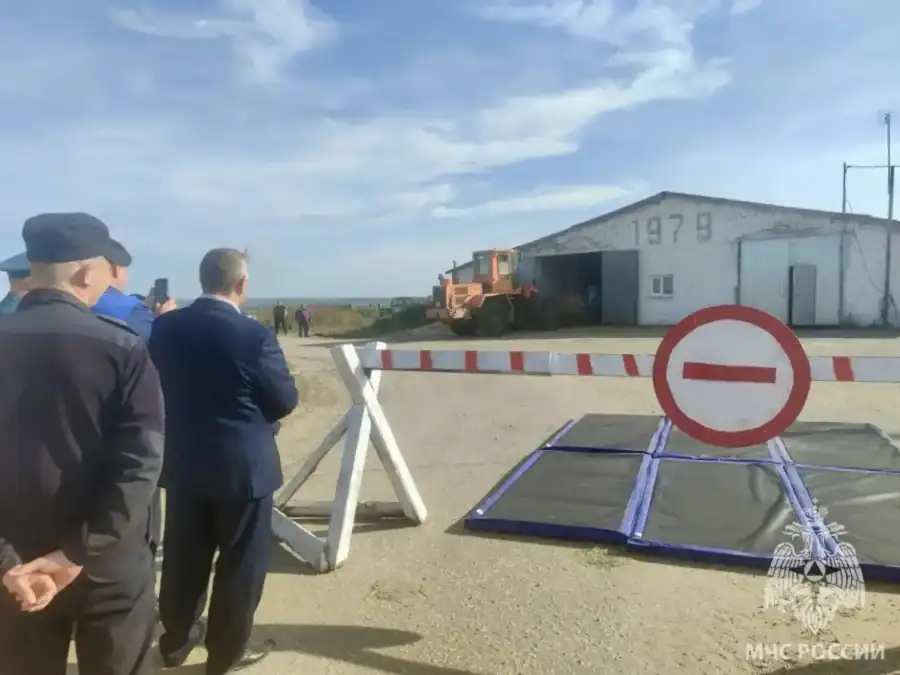 У въезда к зданию установлены шлагбаум и знак запрета движения.