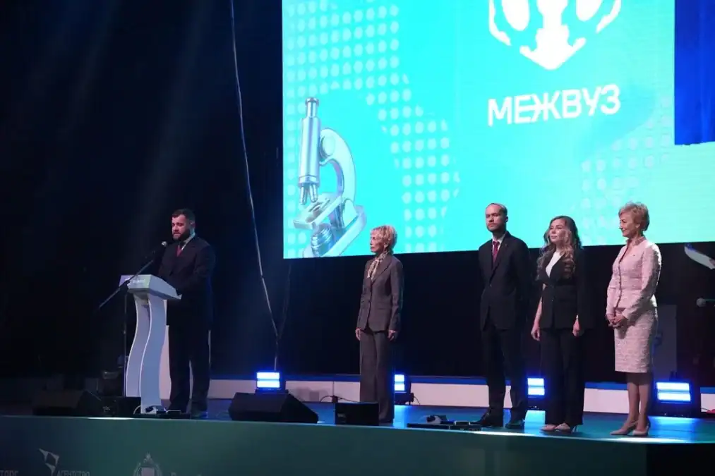 Участники церемонии стоят на сцене перед экраном с надписью «Межвуз».
