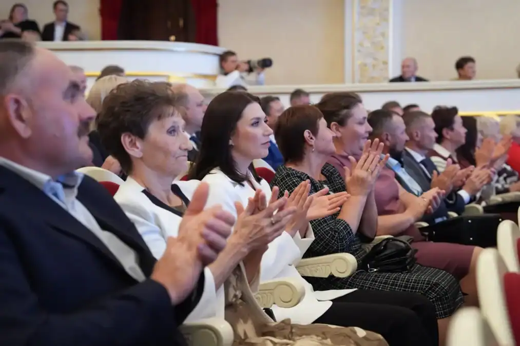 Зрители в театральном зале аплодируют во время церемонии.