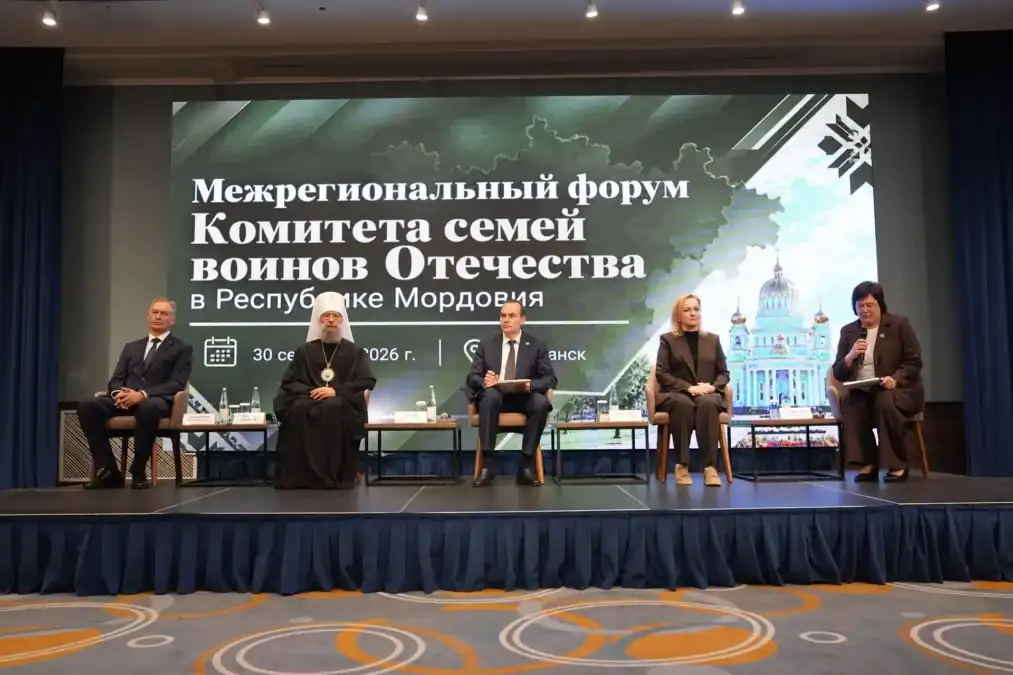 Участники форума сидят на сцене перед экраном с названием мероприятия.