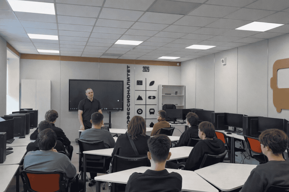 Преподаватель проводит занятие для студентов в компьютерном классе.