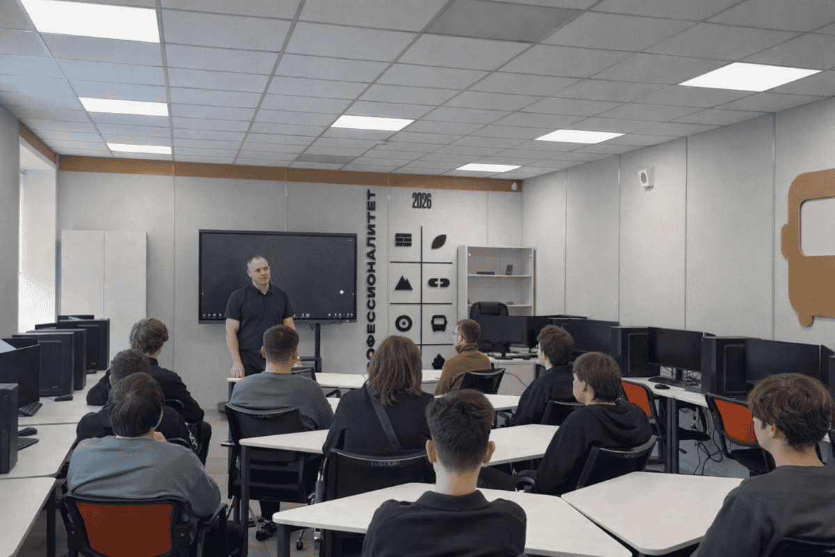 Преподаватель проводит занятие для студентов в компьютерном классе.