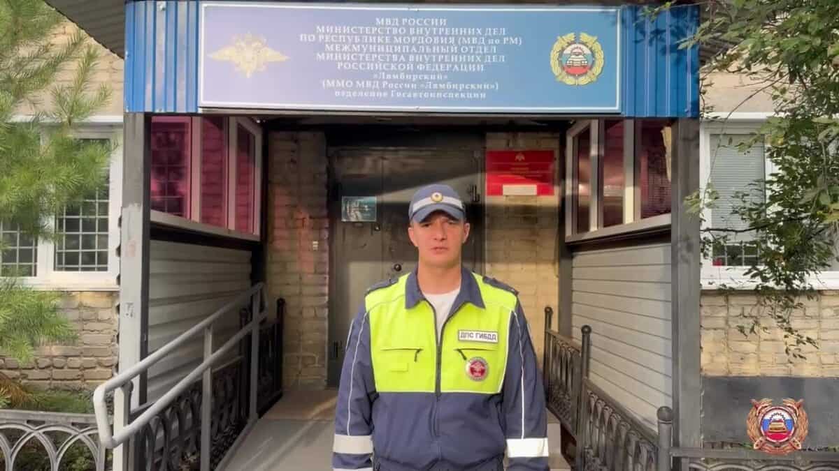 Сотрудник ДПС стоит у входа в здание районного подразделения МВД.
