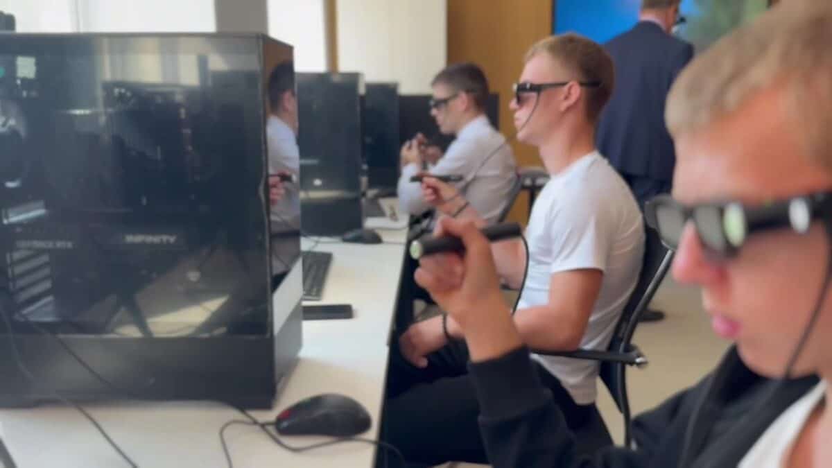 Студенты в защитных очках работают за компьютерами в учебной лаборатории.