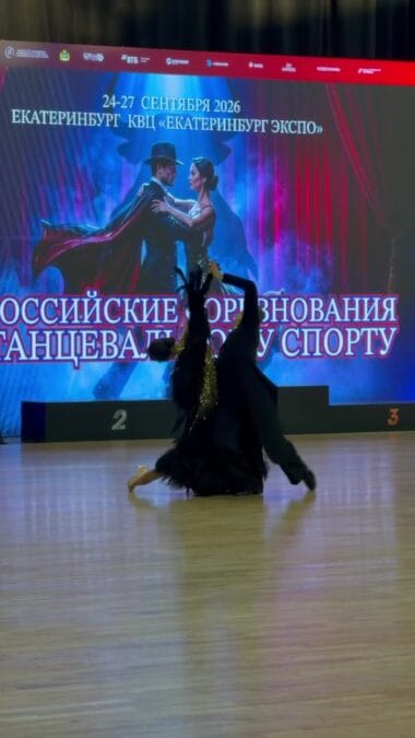 Танцоры исполняют эффектную поддержку перед сценическим экраном.