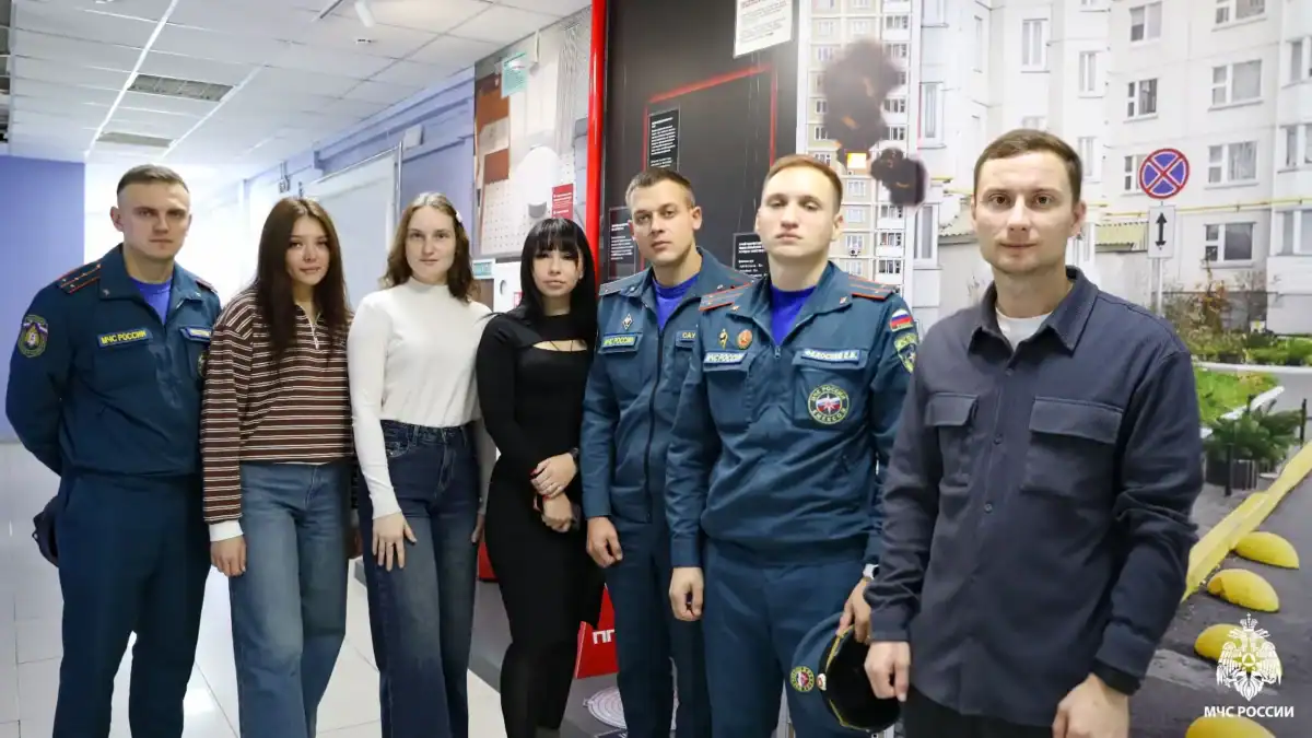 Участники занятия и сотрудники МЧС позируют в коридоре центра.