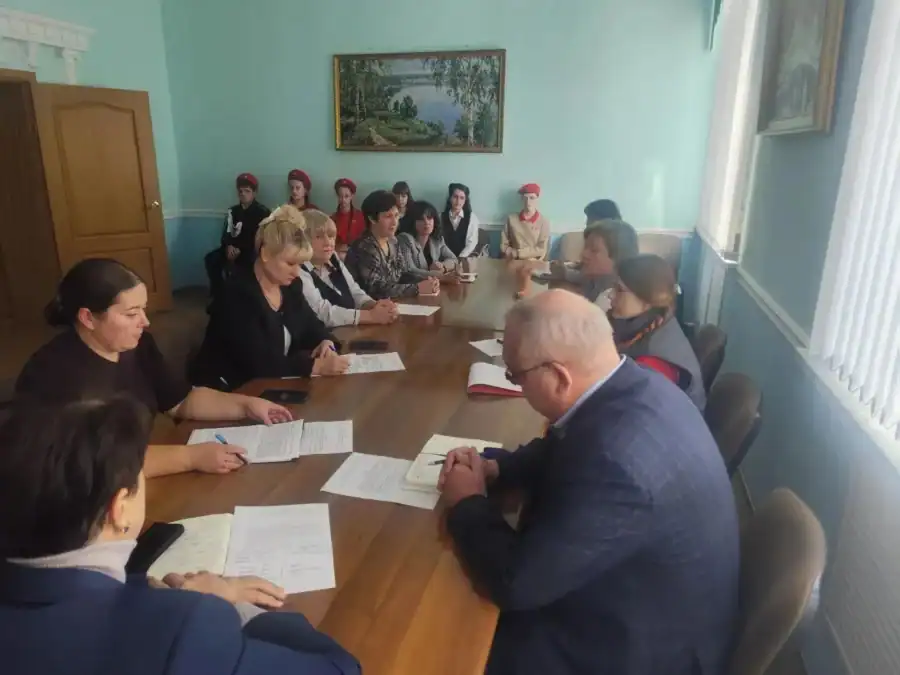 Участники координационного совета обсуждают документы за длинным столом, рядом сидят активисты.