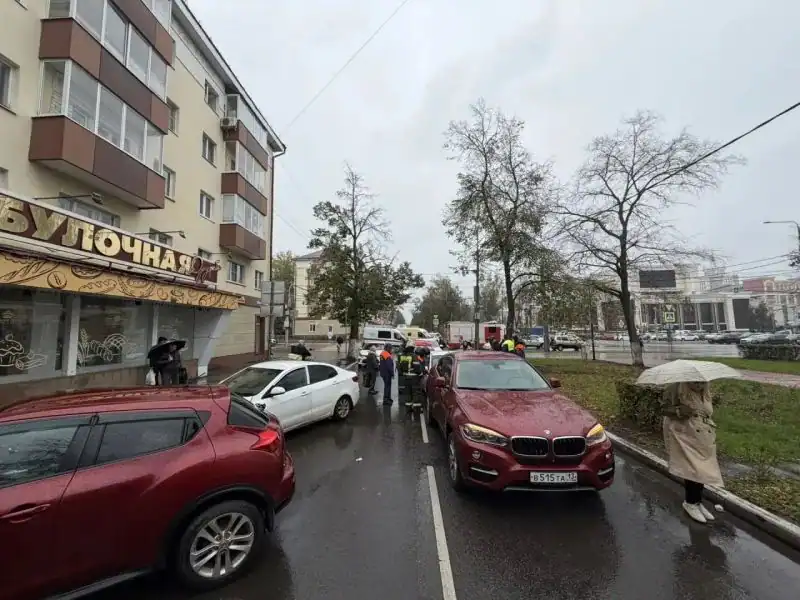 Несколько автомобилей и машины экстренных служб стоят на городской улице.