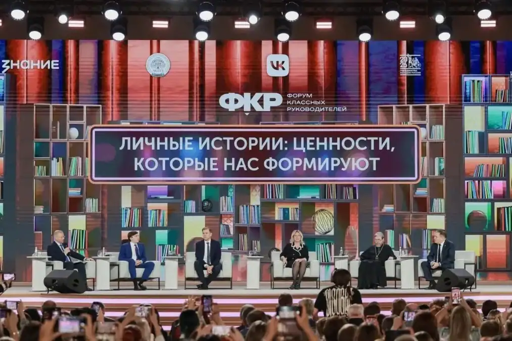 Шесть участников дискуссии сидят на сцене перед экраном с названием встречи.