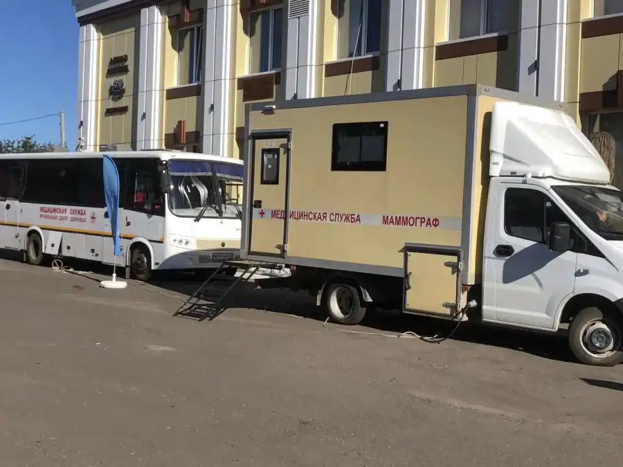 Передвижной маммографический комплекс и автобус мобильного центра здоровья у здания.