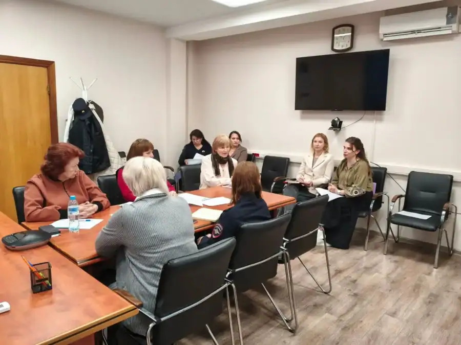 Участники заседания сидят за столом с документами в кабинете.