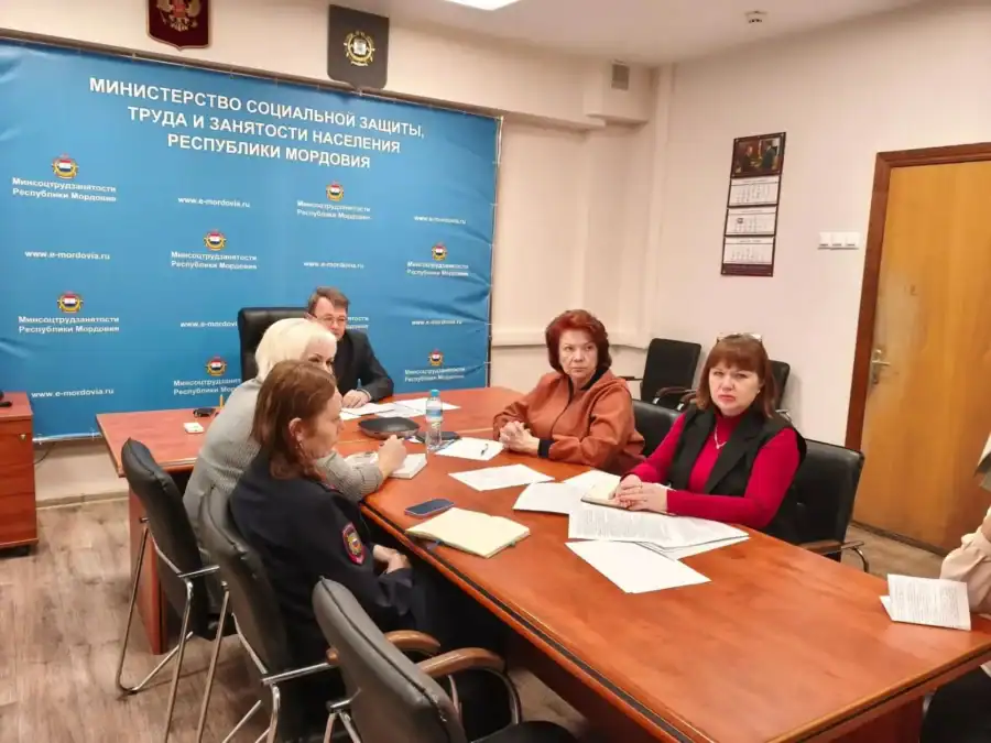 Члены комиссии обсуждают документы за столом в помещении министерства.