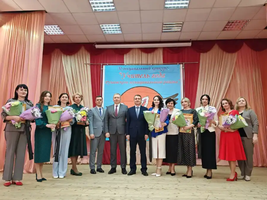 Участницы конкурса с букетами и мужчины в костюмах стоят на сцене.