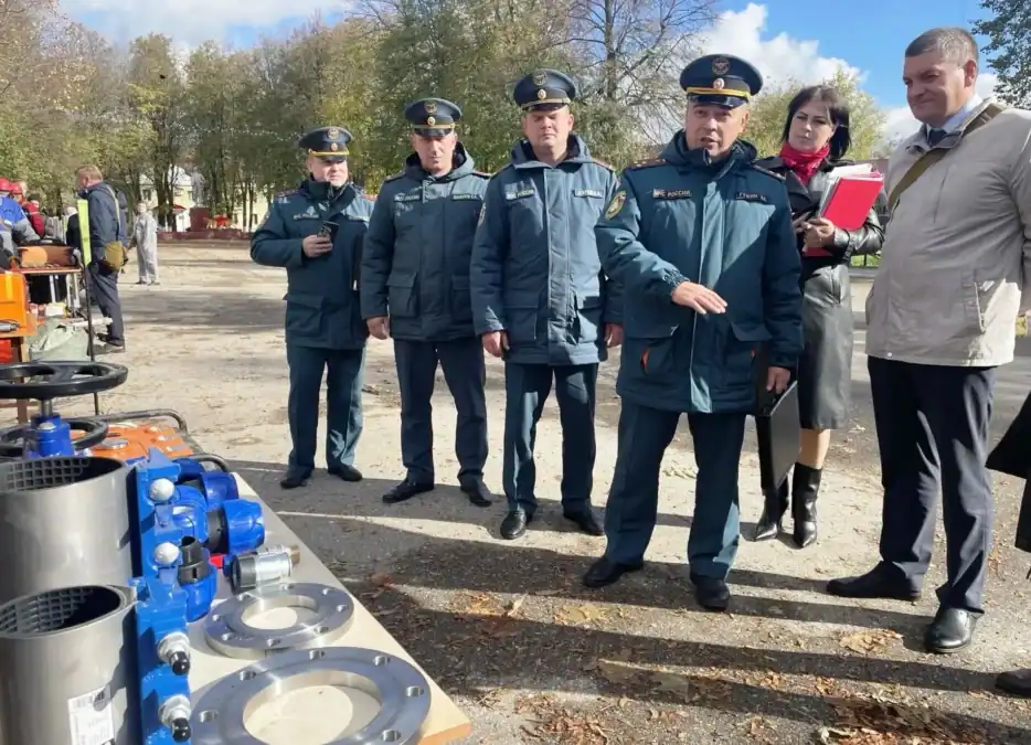 Сотрудники в форме осматривают выставленные элементы коммунального оборудования.