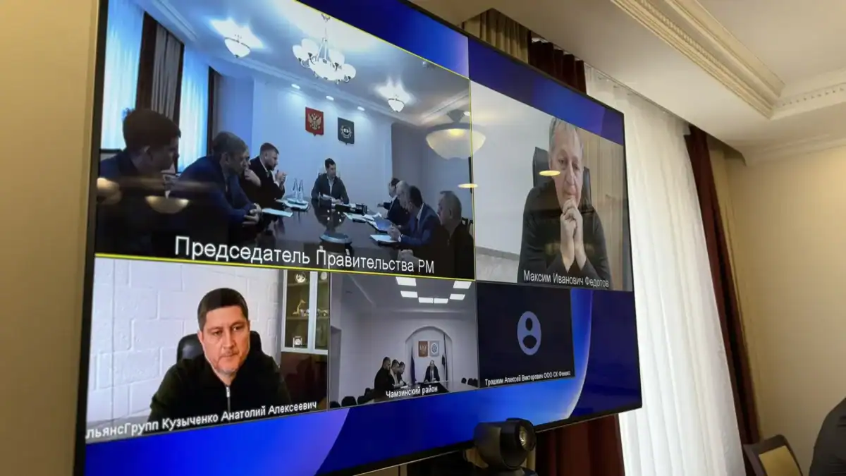 На большом экране показано совещание с участниками по видеосвязи.