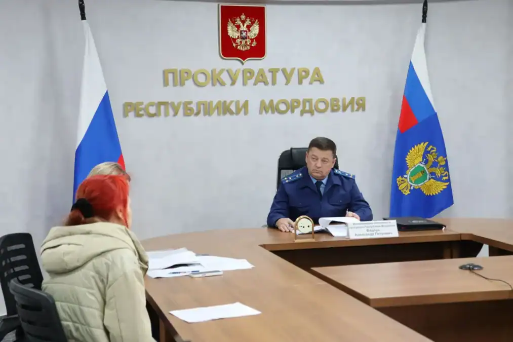 Прокурор рассматривает документы во время приема двух посетительниц.