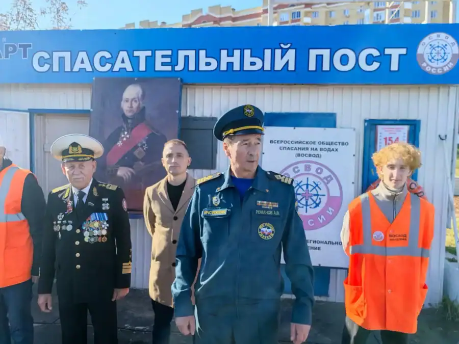 Представители организаторов и участники стоят у здания со знаком «Спасательный пост».