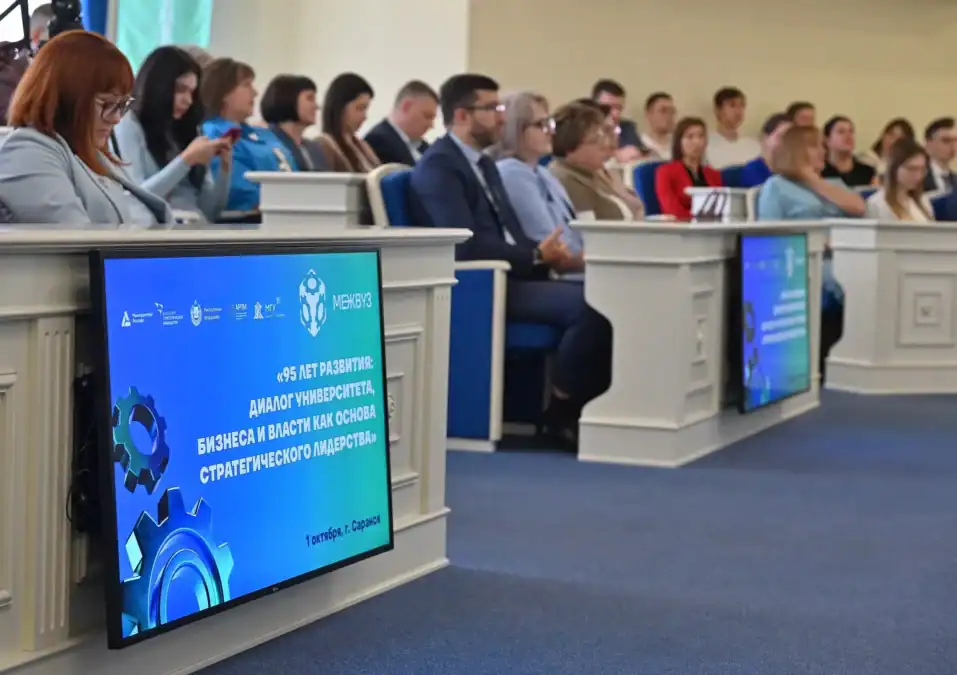 Участники сидят в зале, на экранах показано название экспертной панели.