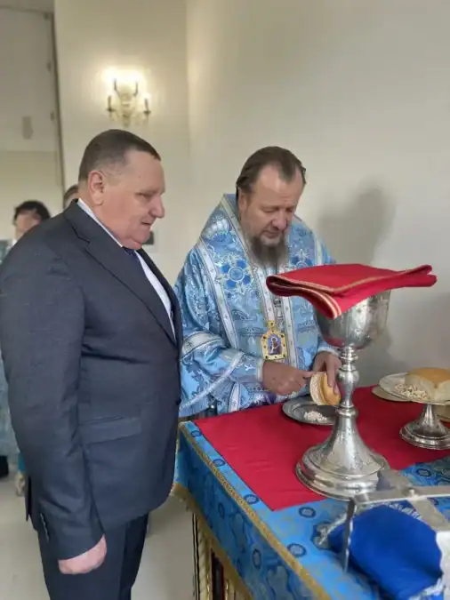 Епископ у престола совершает богослужебное действие с хлебом и церковной чашей.