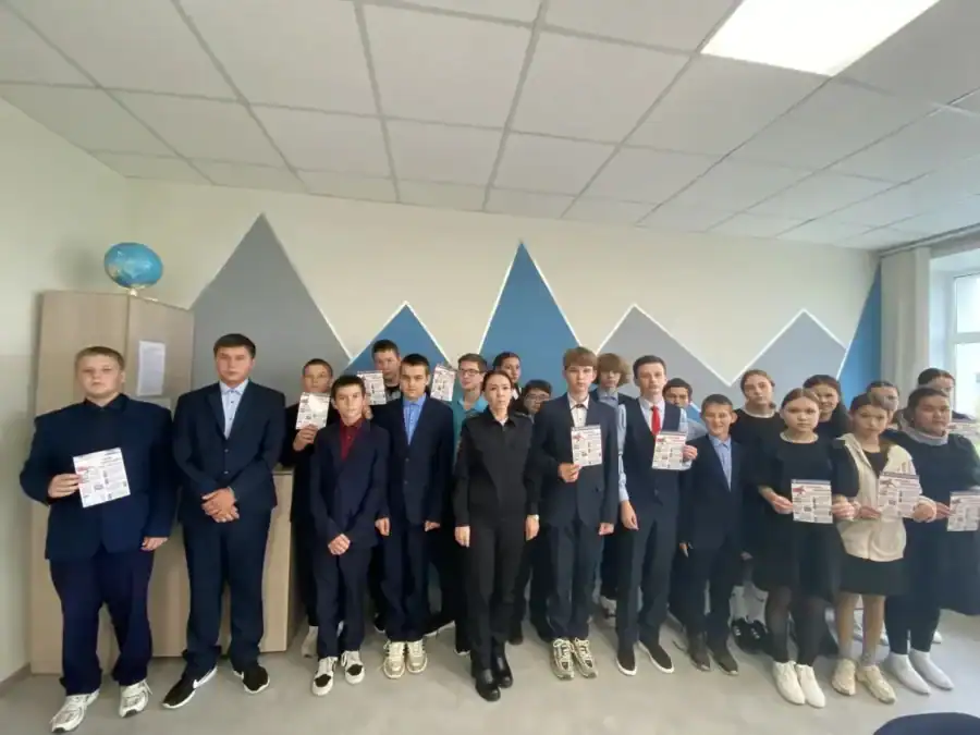 Группа школьников стоит в коридоре, некоторые держат памятки.