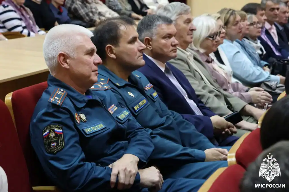 Мужчины в форме МЧС и другие зрители сидят в зале.