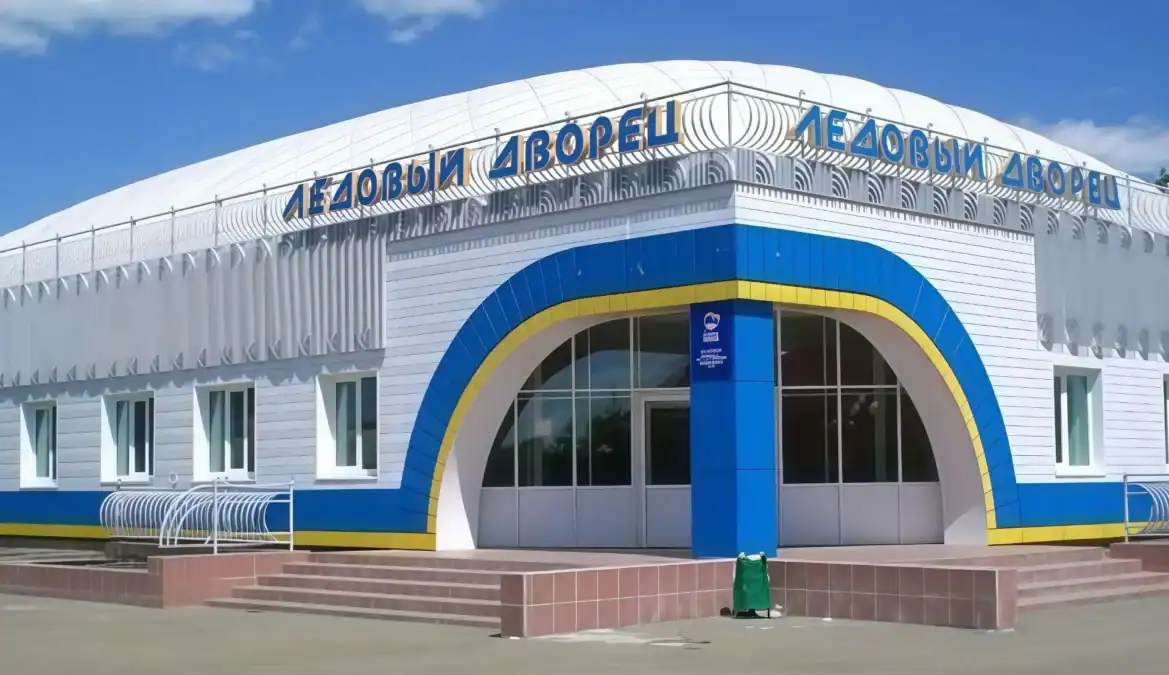 Фасад ледового дворца с арочным входом и вывеской.