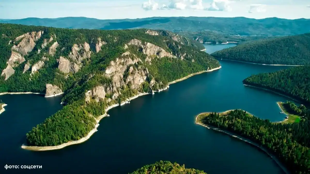 Лесистые скалистые берега и острова среди широкого водохранилища.
