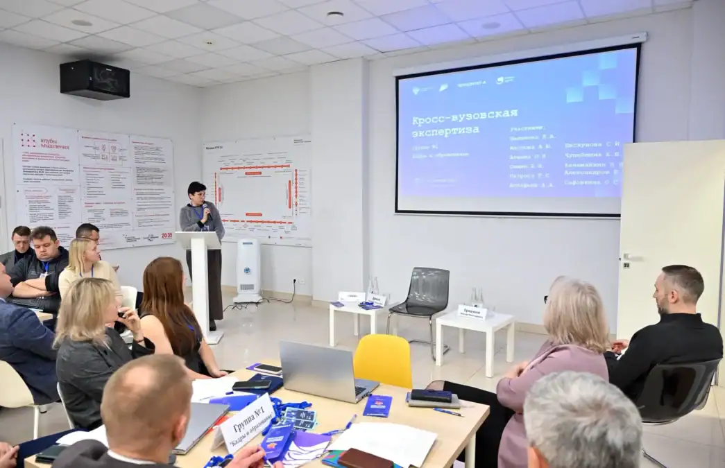 Участники слушают доклад перед экраном с надписью «Кросс-вузовская экспертиза».