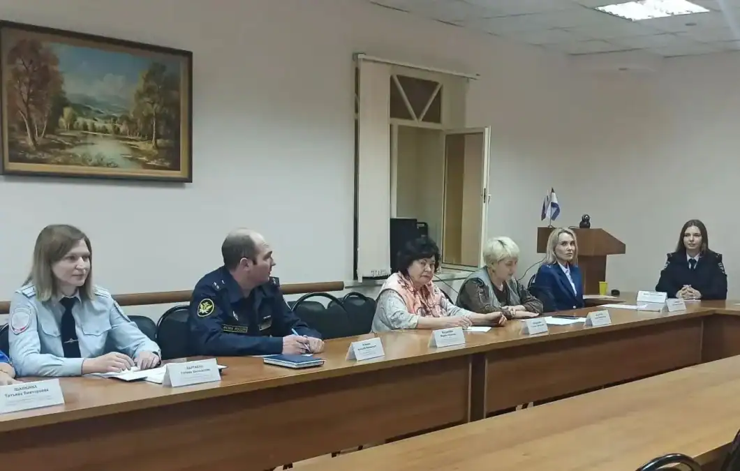 Участники заседания сидят за длинным столом в зале администрации.