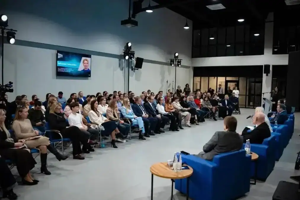 Полный зал слушает выступление участников дискуссии в конференц-пространстве.