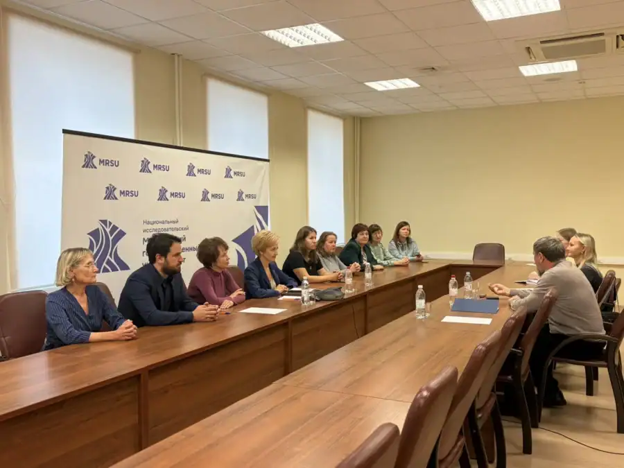 Участники двух рабочих групп обсуждают вопросы за длинным столом в переговорной.